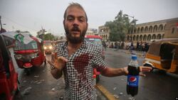 العراقيون يتسلحون بالمشروبات الغازية لمواجهة المسيل للدموع وما دور الاقنعة الزرقاء؟