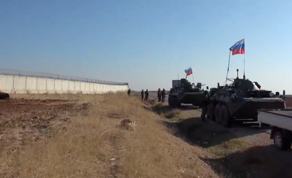Asayish forces dig a trench in front of a Turkish military crossing