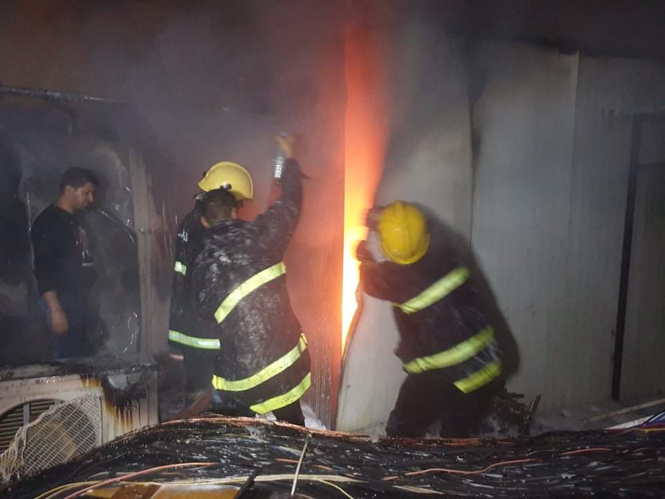 Civil defense teams extinguish a big fire in a market in al-Hilla