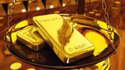 Gold edges up as U.S. dollar retracts