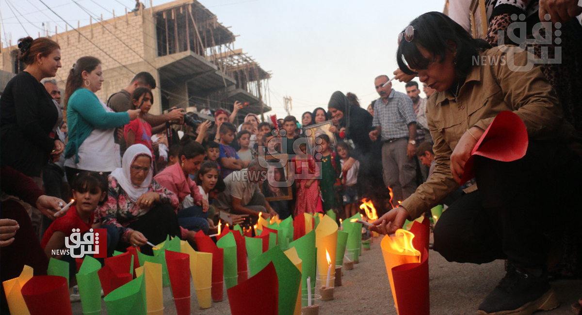 People in al-Qamishli light candles in honor of the 2016 bombing victims