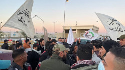 supporters of the Popular Mobilization Forces storm a gate at Baghdad Airport