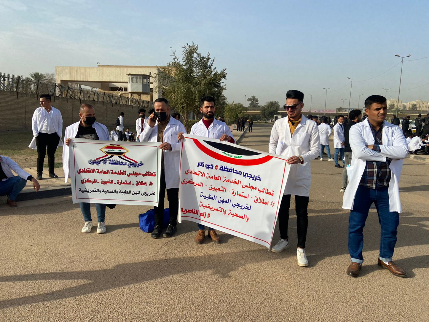 بزي الأطباء والممرضين.. خريجون من ذي قار يتظاهرون أمام مكتب الكاظمي ببغداد