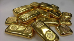 Gold edges lower as dollar gains on hawkish Fed minutes