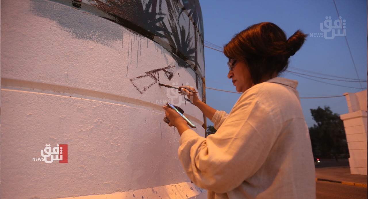 رسامة تنشر ألوان البهجة في شوارع بغداد (صور)