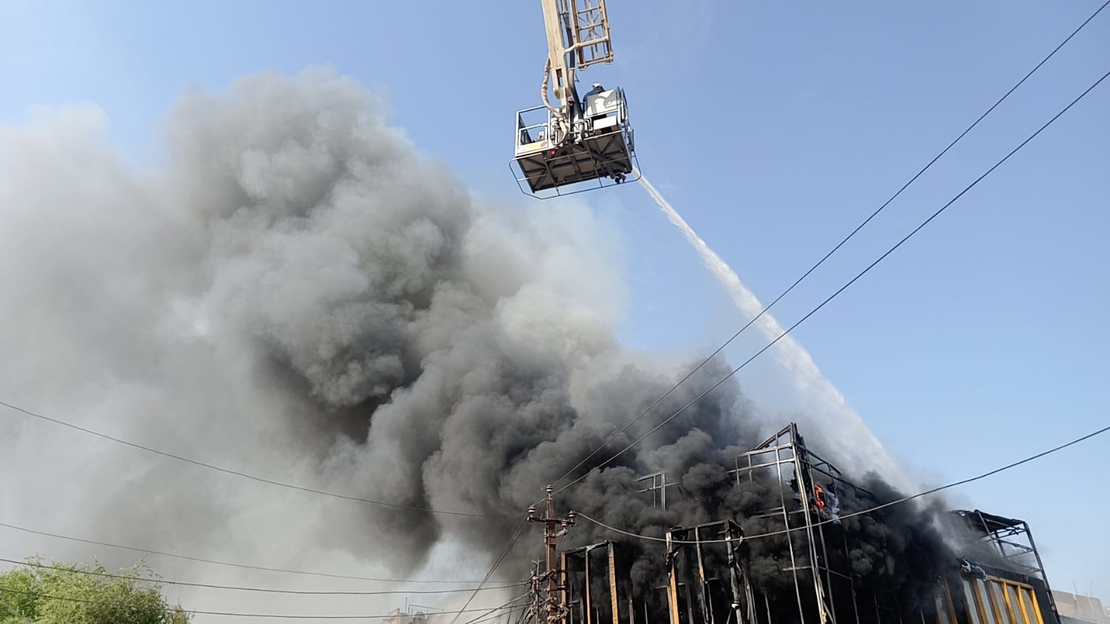 صور وفيديو.. إنقاذ عامل أجنبي من حريق كبير اندلع في بناية تجارية وسط بغداد