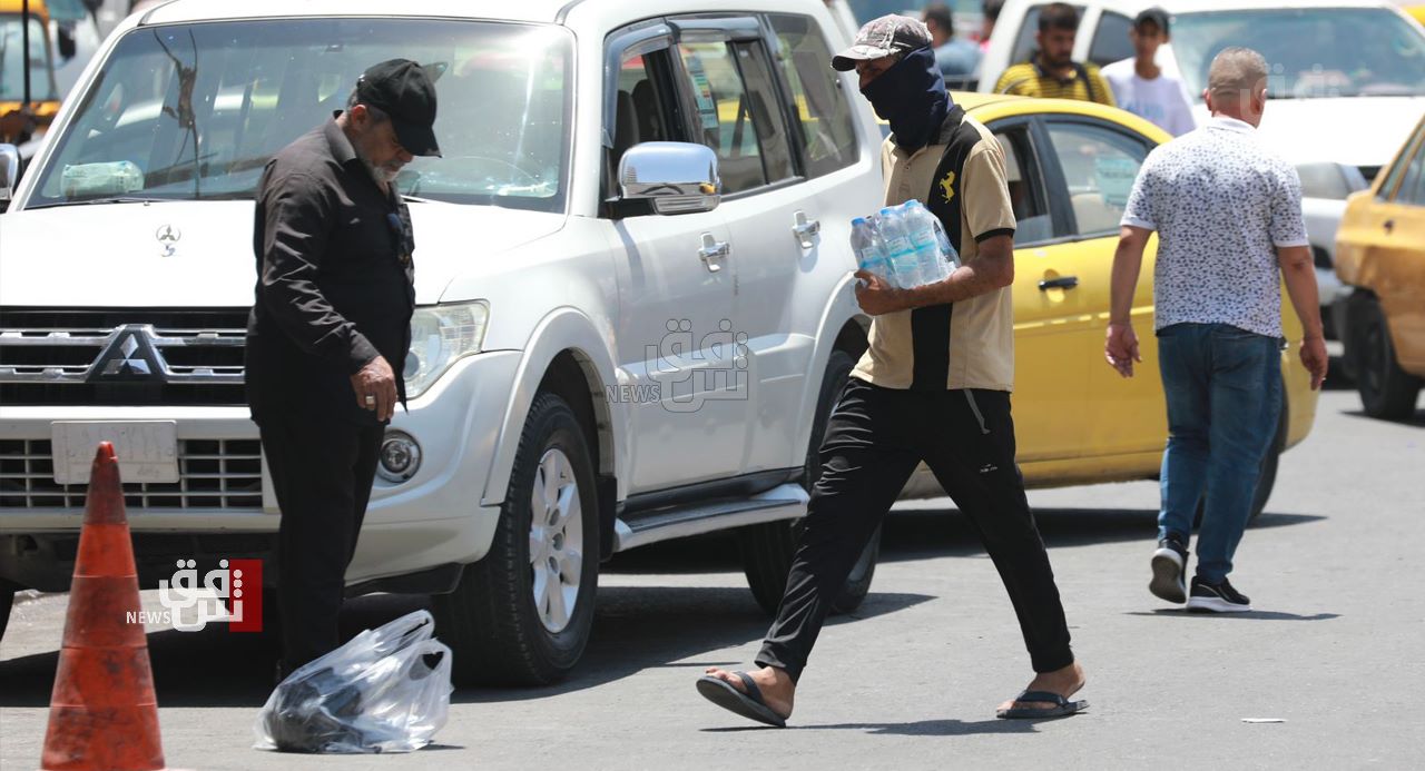 حرارة تموز تدفع البغداديين وسياراتهم للاستحمام بالشوارع وصوت بائع الماء الأعلى في العاصمة (صور)
