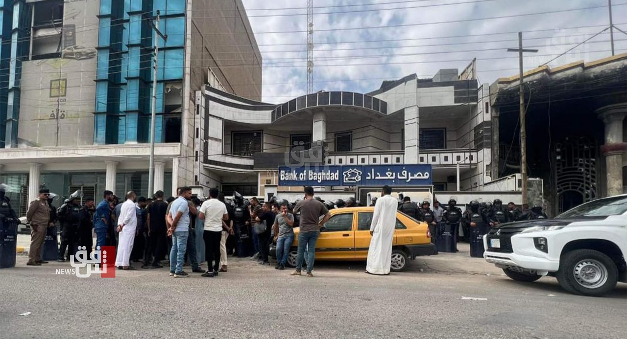 عاملون بشركة نفطية يتظاهرون أمام مصرف امتنع عن صرف رواتبهم جنوبي العراق (صور)