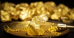 Gold retreats from near four-week peak as dollar ticks up