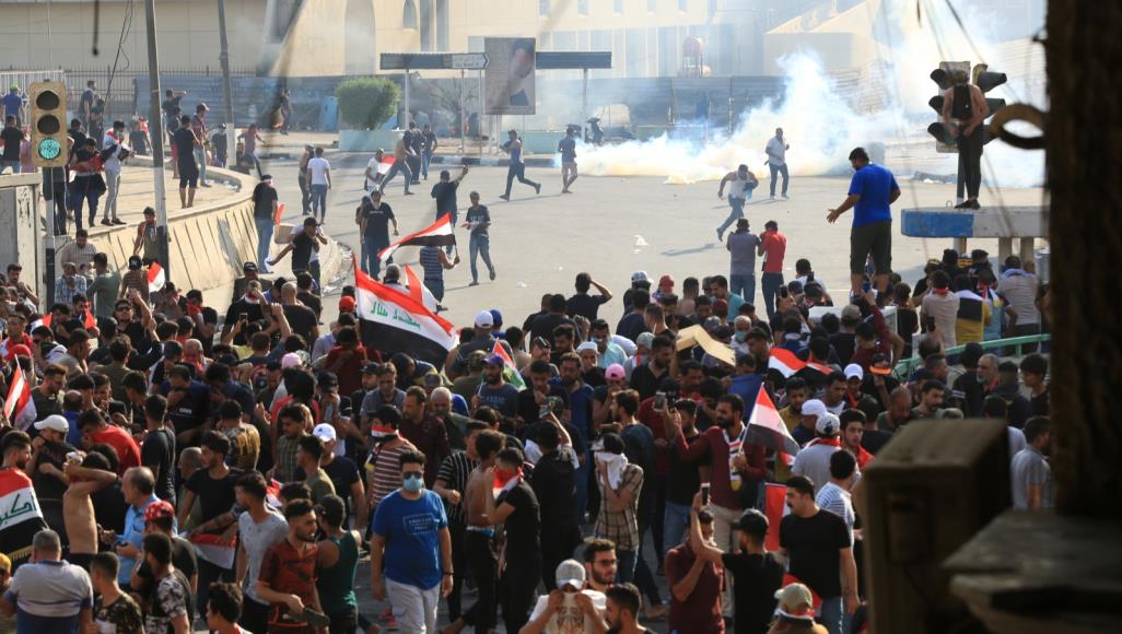 Security forces try to disperse a protest in Tahrir square in Baghdad with live bullets