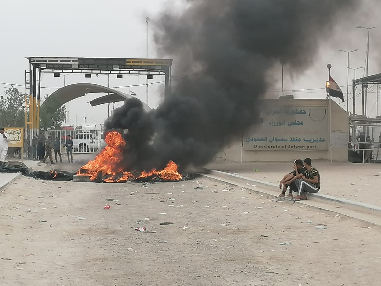 Iraqi demonstrators set fire in front of a border crossing with Kuwait
